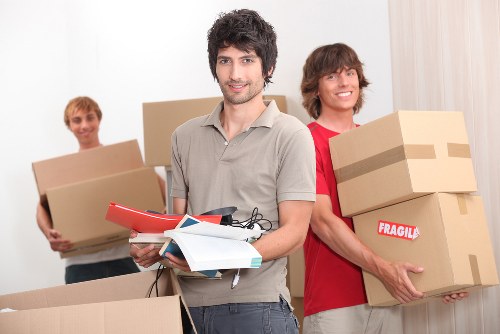 Movers carrying furniture near flats and terraces in East London